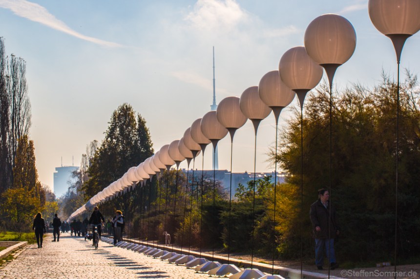 The balloons of the "25 Years Fall of the Wall" installation allign with the Berlin TV tower at the Mauerpark.